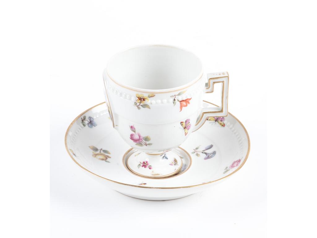 MEISSEN : Tasse et sous-tasse en porcelaine blanche à décor peint de fleurs, d'insectes et de couple dans des médaillons. Marquée. Bon état.