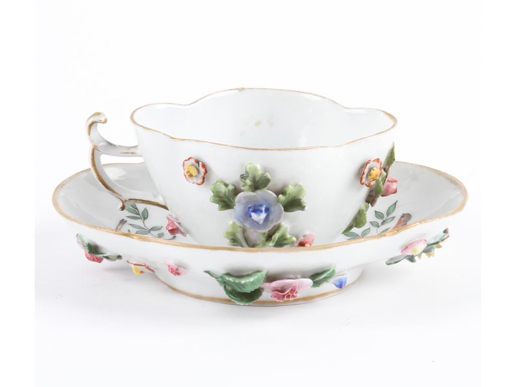 SAXE : Tasse et sous-tasse en porcelaine blanche de forme quadrilobée à décor peint et en application de fleurs et oiseaux marqués. Bon état général.