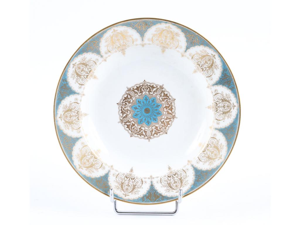 SEVRES : Assiette creuse en porcelaine blanche à décor peint de lambrequins dorés sur fond bleu-turquoise. Epoque Louis-Phillipe. Datée 1844 et marquée. Diamètre : 23.5 cm. Bon état.