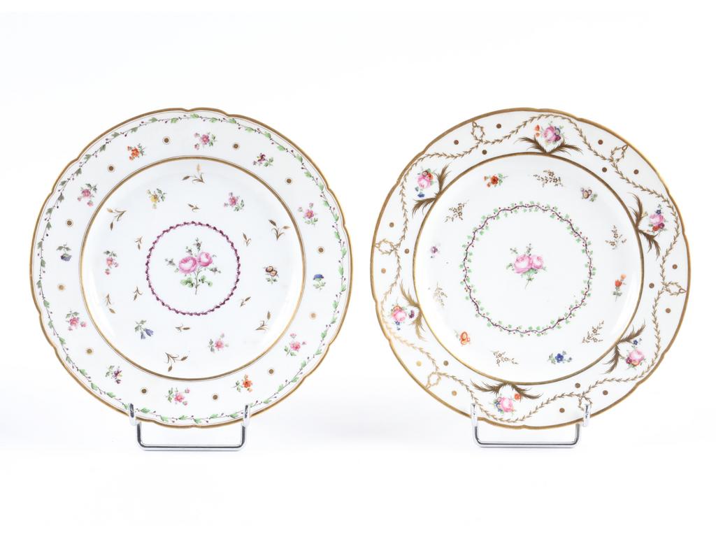 PARIS, Rue de Bondi : Paire d'assiettes en porcelaine blanche, ailes en accolades surlignées de doré. Au centre, un bouquet de roses et l'ensemble peint d'un semis de fleurettes. Epoque Louis XVI. Diamètre : 25 cm. (Marquées, infimes reprises de dorure)