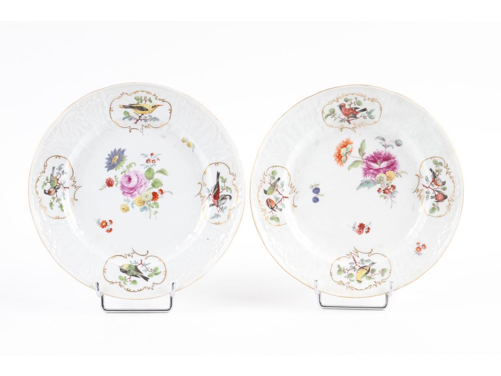 MEISSEN : Paire d'assiettes en porcelaine blanche à léger relief ornées de bouquets et d'oiseaux peints avec rehauts dorés. Marquées. Diamètre : 25 cm. Bon état.