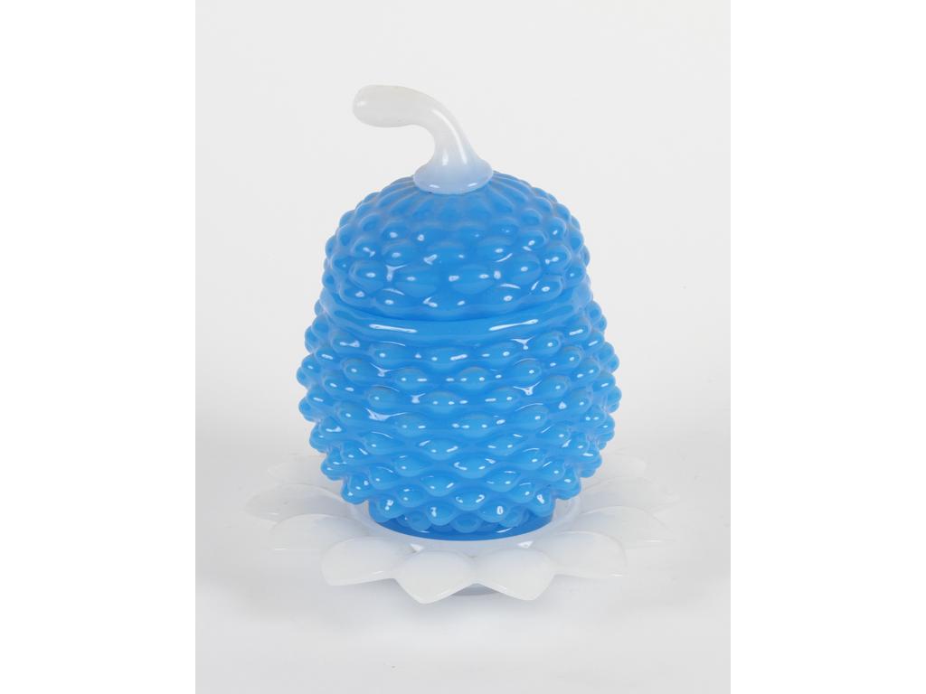 Boîte en opaline moulée bleue à décor perlé en relief à l'imitation d'un fruit. La coupelle et le fretel en opaline blanche. Hauteur : 17 cm. (un éclat à l'intérieur du col, un éclat sur le rebord de la coupelle)