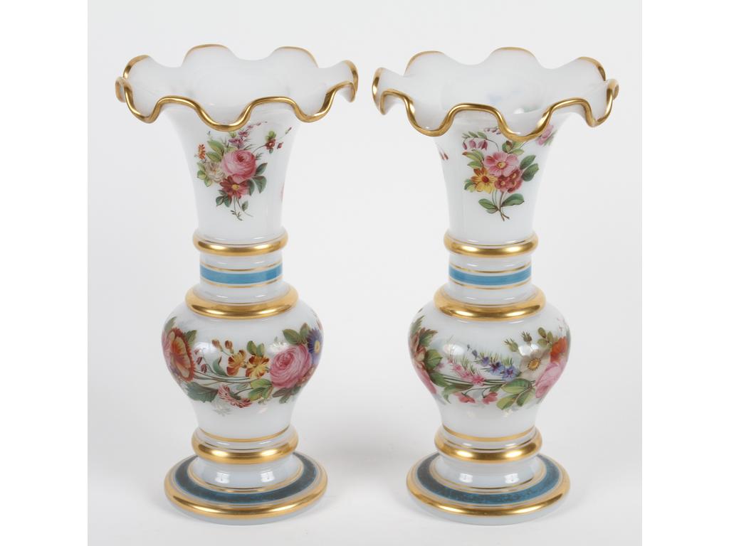 Paire de petits vases en opaline blanche à bords en collerette. Décor peint de fleurs et de liserés bleus et dorés. Bon état, infimes usures à la dorure. Hauteur : 25 cm.