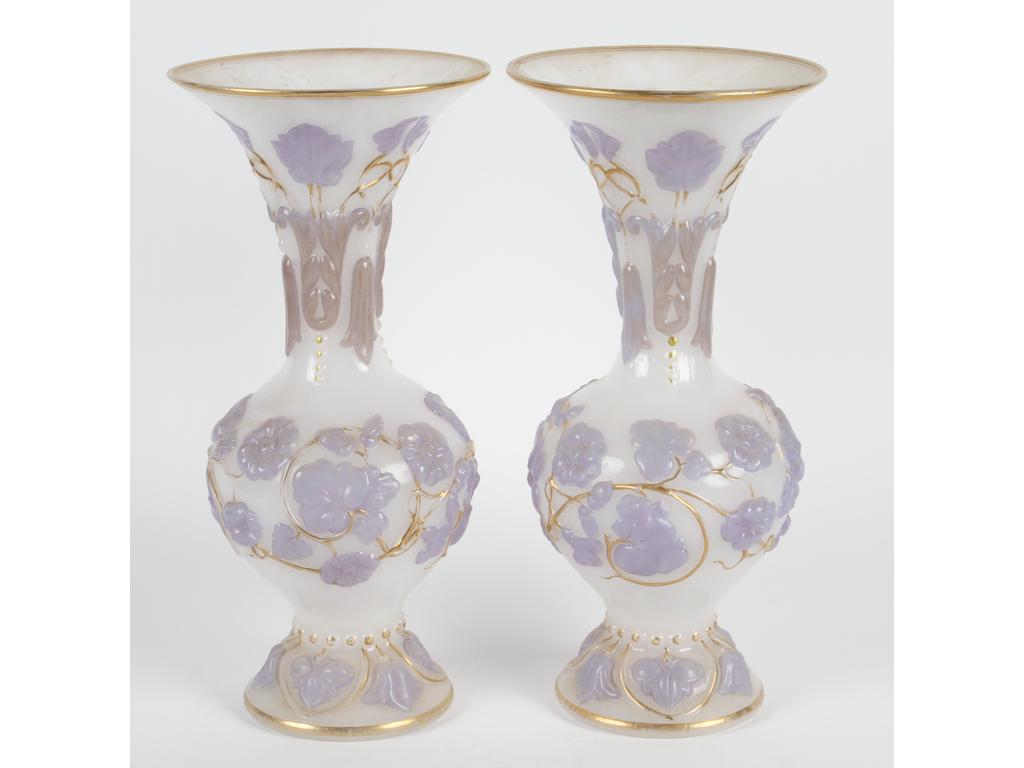 Paire de vases balustres en opaline blanche moulée à décor en relief et peint violet de branchages fleuris rehaussés de doré. Bon état général, usures à la dorure. Hauteur : 35 cm.
