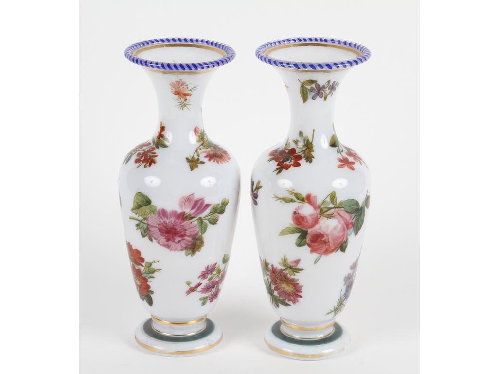 Paire de vases balustres en opaline blanche à décor peint de fleurs. Les cols ornés d'un liseré en verre  bleu et blanc filigrané à reticello. Bon état général.