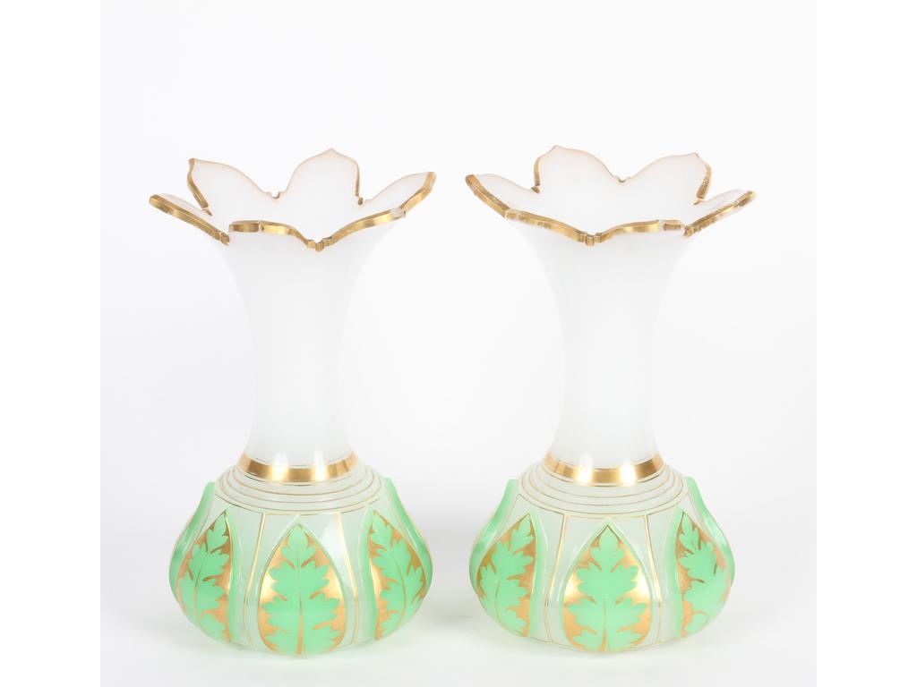 Paire de vases en opaline blanche doublée verte à décor de feuillages taillés. Les cols évasés surlignés de doré. (Bon état général et petites usures à la dorure). Hauteur : 22 cm.