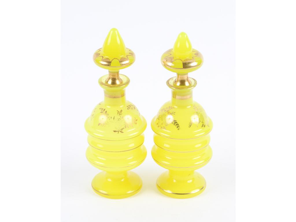 Paire de flacons en opaline jaune à décor de bouquets et de liserés dorés. (Usures à la dorure, bon état général). Hauteur : 20 cm.