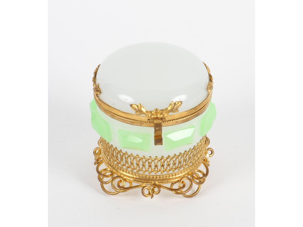 Boîte ronde en opaline blanche et verte à décor de cabochons taillés sur une monture en laiton et tôle dorée. Bon état. Hauteur : 8 cm.