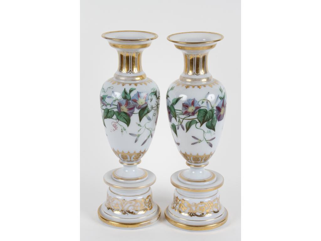 Paire de grands et jolis vases sur socle en opaline blanche de forme balustre à décor peint de fleurs de liserons et rehaussés de cannelures, palmettes et rinceaux feuillagés dorés, (Bon état général, à signaler : un feuillage vert effacé, et usures éparses à la dorure). Hauteurs : 45 cm.
