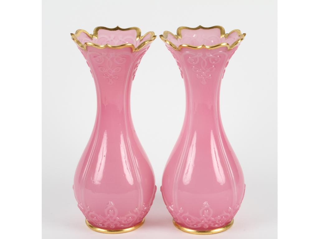Paire de vases en opaline rose moulée à décor de lambrequins en léger relief. Les bases et les cols réhaussés de dorure. Hauteur : 30 cm (Bon état)