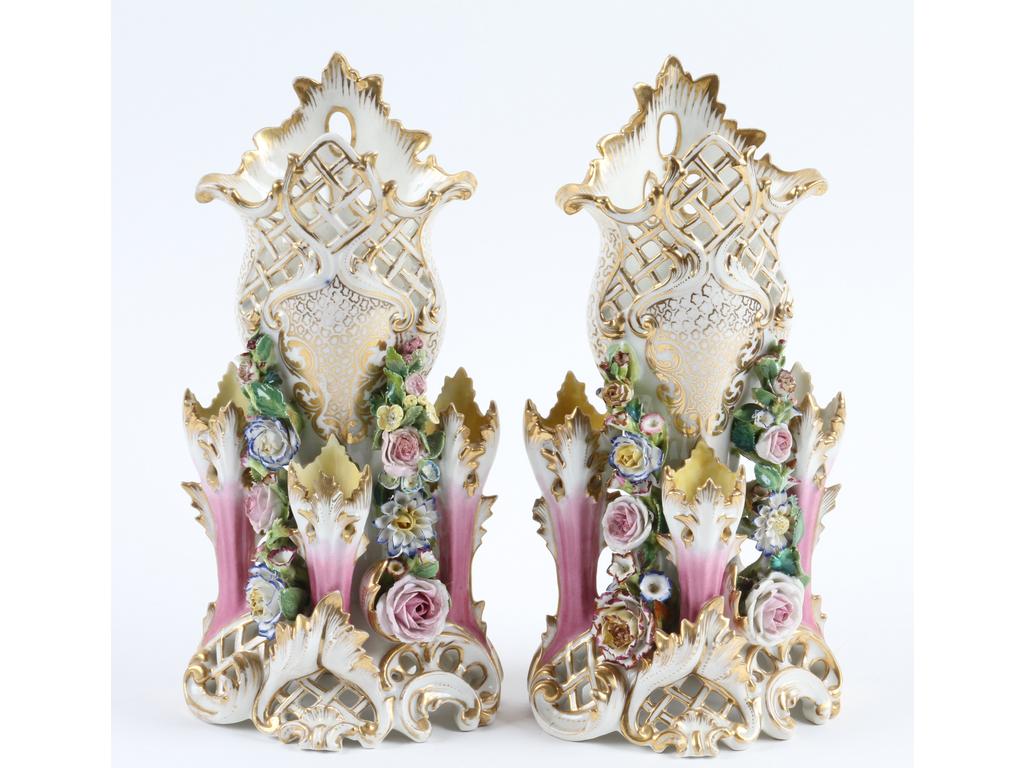 PARIS, Jacob PETIT : Paire de vases en porcelaine blanche et dorée richement ornés en relief de fleurs et de trois coroles formant soliflores. Base et col ajourés, un seul vase sur les deux marqué JP. (Bon état général, quelques accidents sur les fleurs). Hauteur : 30 cm.