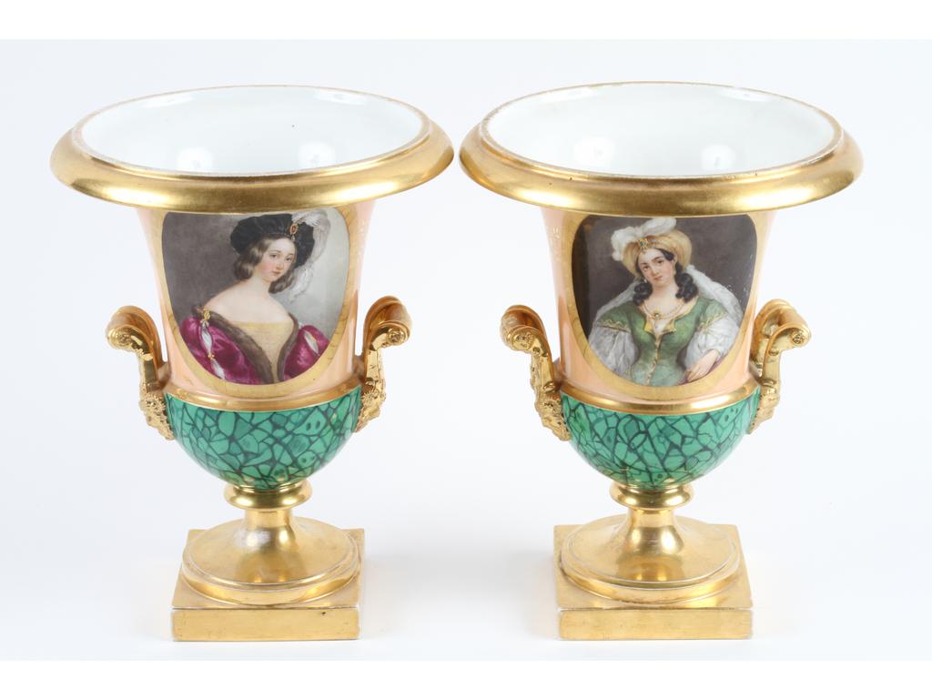 PARIS, Edouard HONORE : Paire de vases Médicis d'époque Restauration en porcelaine blanche entièrement peints et dorés de deux personnages. La base à l'imitation de la malachite. (Usures à la dorure, bon état général). Hauteur : 25 cm.