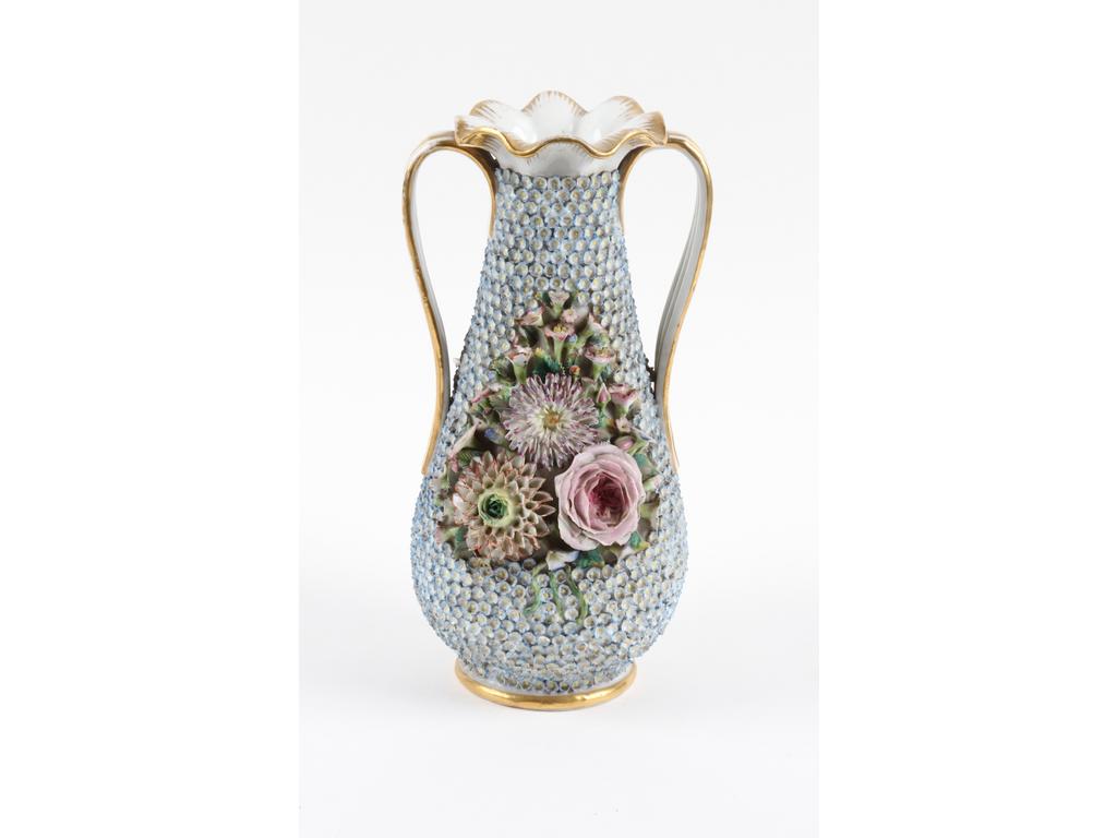 PARIS, Jacob PETIT : Vase balustre en porcelaine blanche entièrement orné de petites fleurs bleues en relief et de deux compositions florales. Le col et les anses dorés. Marqué J.P. (Bon état général, quelques accidents sur les fleurs). Hauteur : 29 cm.