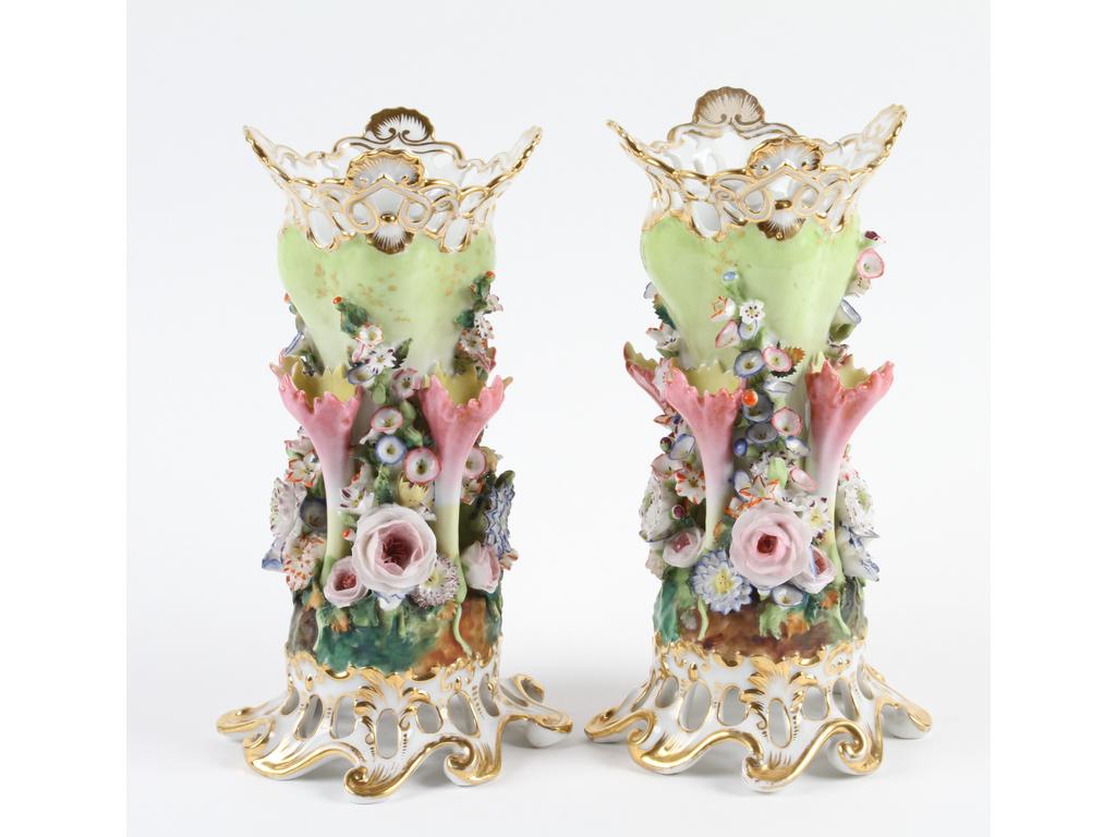 PARIS, Jacob PETIT : Paire de vases en porcelaine blanche et socles ajourés à très riche décor peint de multiples fleurs en relief. Socles et cols rehaussés de dorure. Les deux marqués J.P. (Bon état général, quelques éclats aux fleurs). Hauteur: 24 cm.