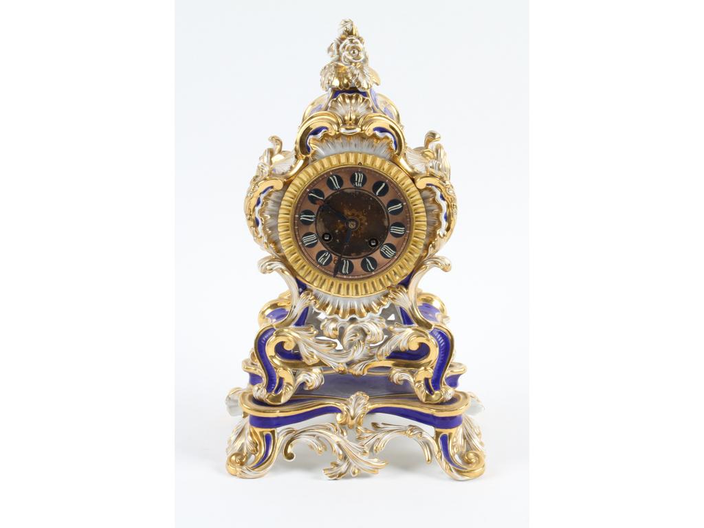 Pendule de style Louis XV en porcelaine blanche et dorée sur fond bleu. Mouvement à fil signé PONS et daté 1825. (Mouvement à réviser). Hauteur : 35 cm.