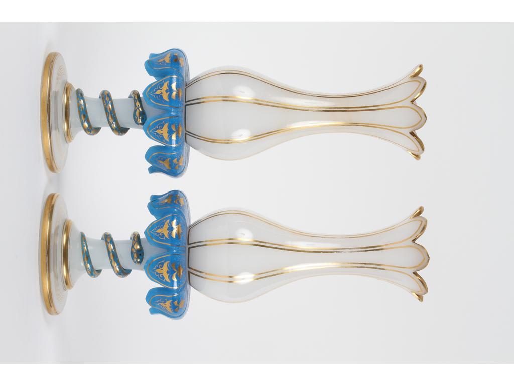 Paire de jolis vases en opaline blanche et bleue avec réhauts dorés, reposant sur des pieds ornés de serpents enroulés. Hauteur : 35 cm. (Un infime éclat sur une pétale bleue, à signaler des altérations et la maladie du verre sur l'opaline bleue)