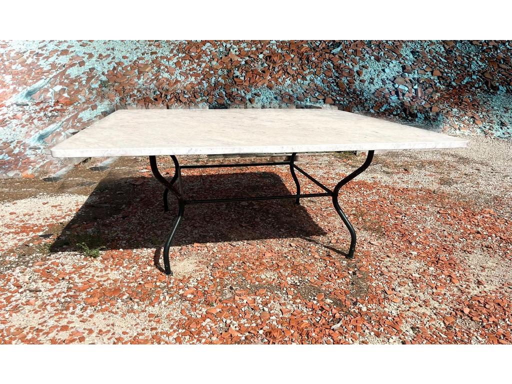 VENDUE SUR DESIGNATION : Hervé BAUME : Table de jardin piètement en fer forgé. Plateau de marbre dépoli blanc. (Quelques égrenures sur les cotés). Dim :74x180x180 cm. Enlèvement sur rendez-vous
