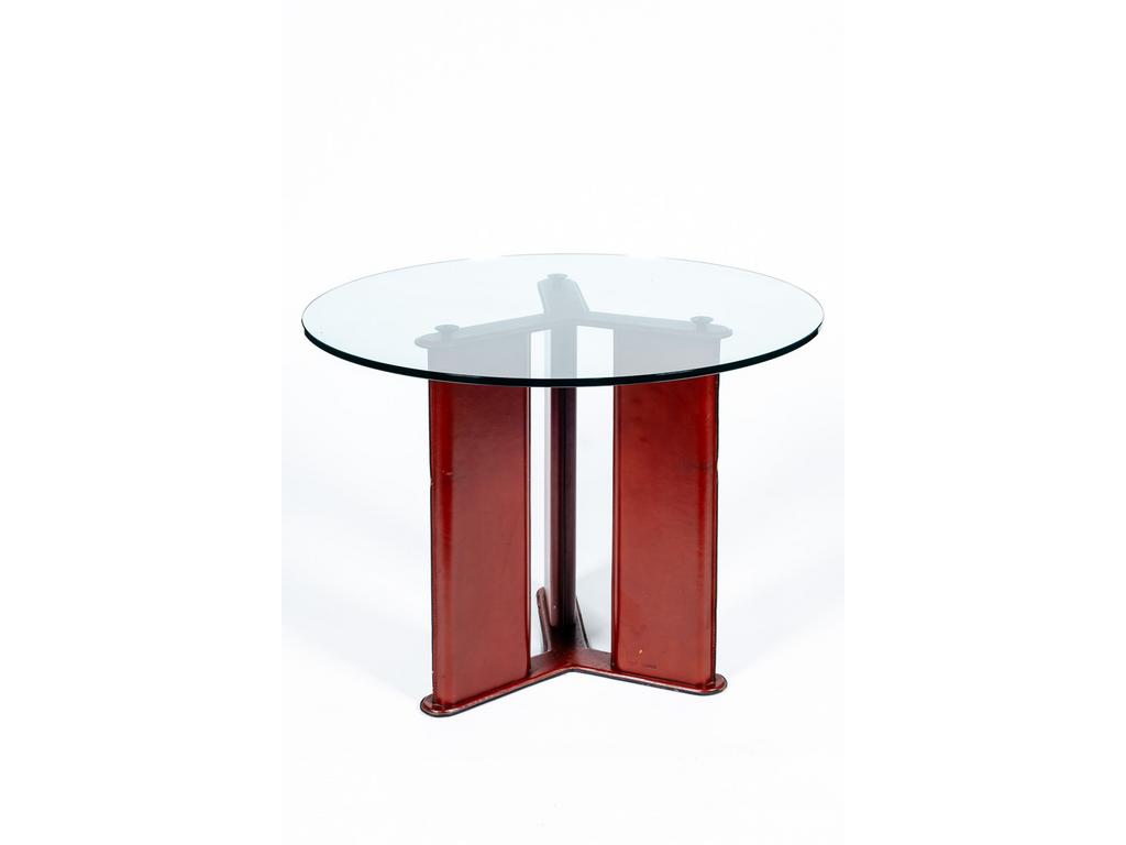 Tito AGNOLI, édité par Matteo GRASSI : Table circulaire, plateau en verre reposant sur un piétement tripode gainé de cuir surpiqué. Cachet de l'éditeur. (Usures et chocs au piétement). Hauteur : 75 cm. Diamètre : 100 cm