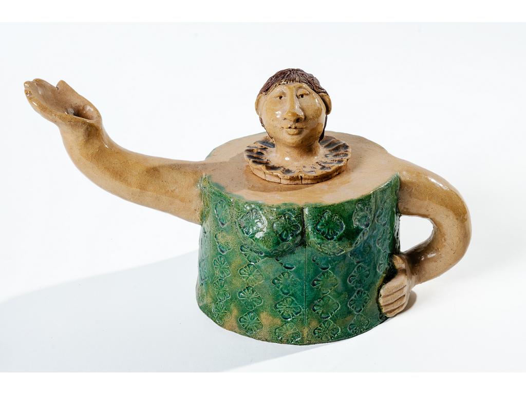Julie ARMANVILLE, atelier DIDIMATUS :  Théière en terre cuite émaillée représentant un personnage, un bras dans le dos en guise de poignée, et un bras tendu en guise de bec verseur. Marqué. Bon état. Hauteur : 18 cm.