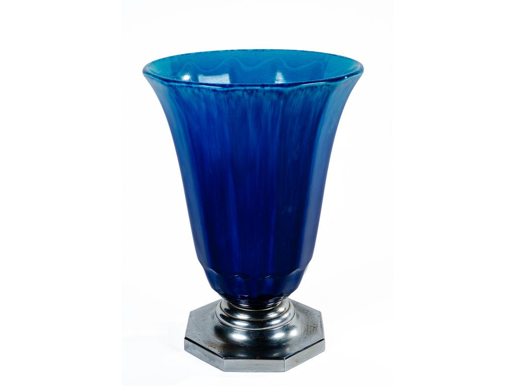SEVRES, Paul MILLET (1870-1950) : Vase tulipe en faïence émaillée bleue-turquoise et bleu-roi, reposant sur un socle chromé. Signé. (Usures au chrome). Hauteur : 27 cm.