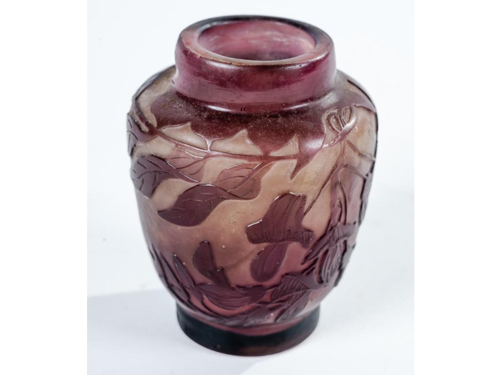 Etablissement GALLE : Petit vase en verre doublé blanc et violet à décor de fleurs, signée à l'étoile. Bon état. Hauteur : 7 cm.