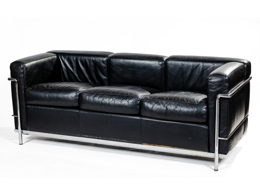 LE CORBUSIER - Edition CASSINA : Canapé trois places. Structure en acier tubulaire chromé. Garniture des coussins en cuir noir (cuir abîmé et griffé sur les accoudoirs et haut des dossiers). Structure signée LC2, N° 120928. Longueur : 180 cm.