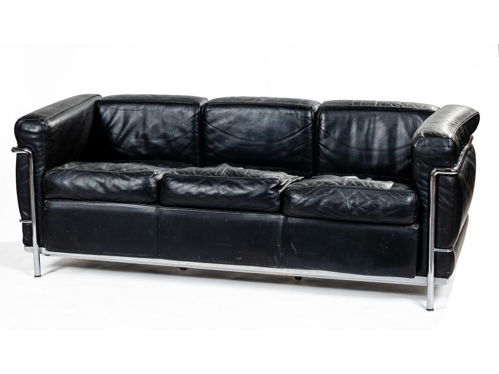 LE CORBUSIER - Edition CASSINA : canapé trois places. Structure en acier tubulaire chromé. Garniture des coussins en cuir noir. Structure signée LC2, N°59148. Longueur : 180 cm. (Cuir en état d'usage, usures et tâches éparses, un bout d'accoudoir usé).