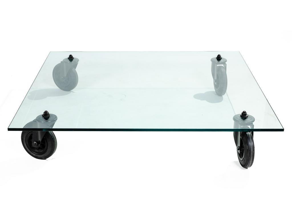 Gae AULENTI, pour FONTANA ARTE : Table basse carrée, modèle TAVOLO en verre, reposant sur quatre roulettes type chariot en caoutchouc. Dim : 130 x 130 x 25 cm. (Infime éclat à un angle).
