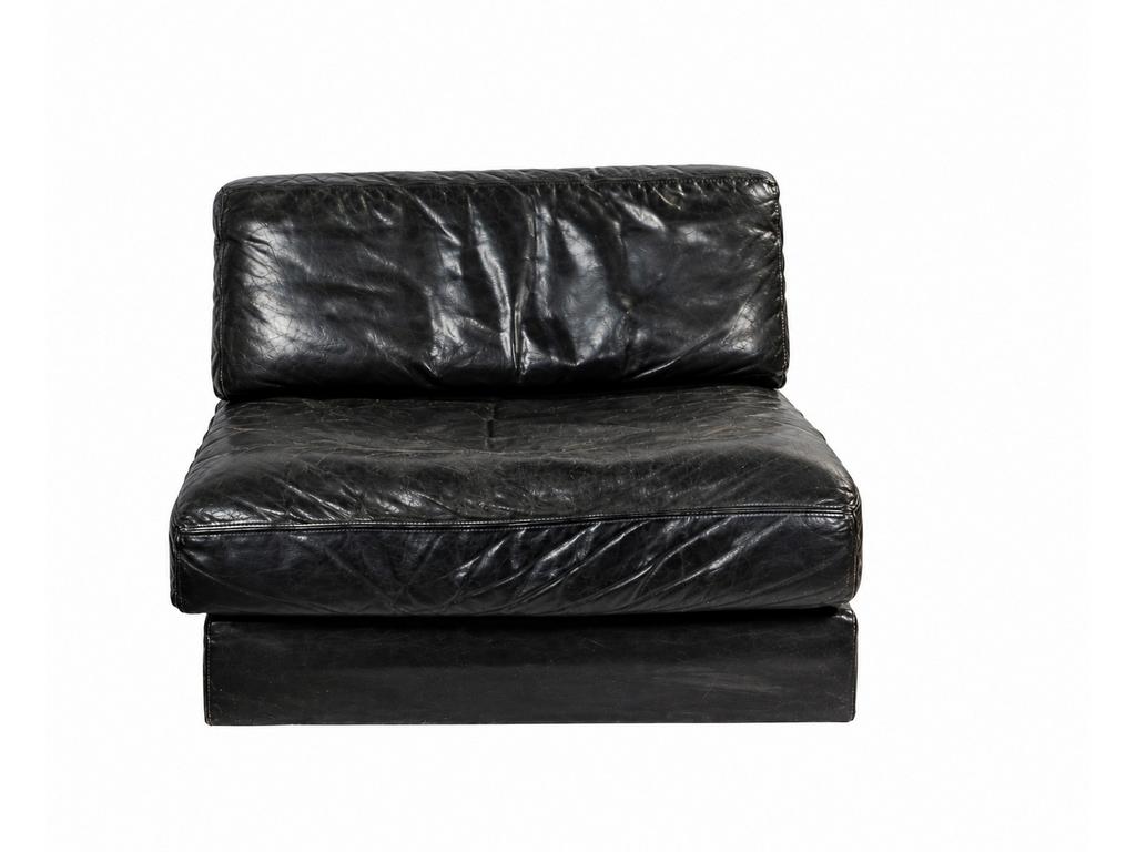 DE SEDE Exclusiv  : Chauffeuse en mousse et cuir noir. Garniture signée dans l'impression (cuir usé). Dim assise : 100 x 85 cm.