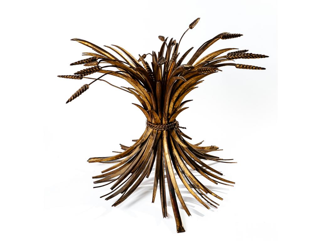 Dans le goût de Robert GOOSSENS : Piètement de table basse en tôle et métal doré à décor d'une gerbe de blés et feuillages. Travail moderne italien. Hauteur : 44 cm. (Vendue sans le plateau en verre)