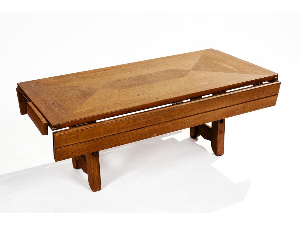 Editions VOTRE MAISON : Table basse en chêne modulable en table de salle à manger avec deux pieds réhausseurs supplémentaires. Le plateau s'agrandi par deux volets latéraux rabattables. Hauteur de la table basse : 49 cm. Plateau rabattu : 121 x 61 cm. (Une fixation des allonges cassée et absente, quelques tâches et chocs sur le plateau)