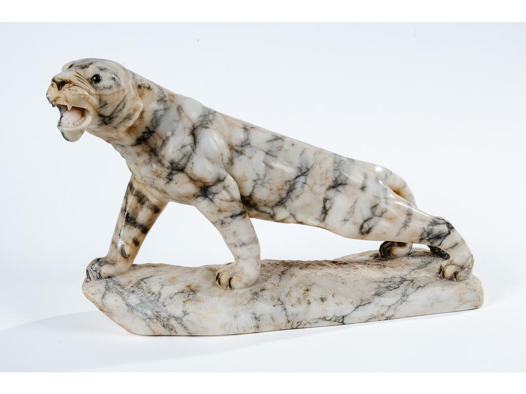 Tigre en albâtre sculpté, les yeux en verre. Non signé. Epoque 1930/1940. Longueur : 50 cm. Hauteur : 31 cm.