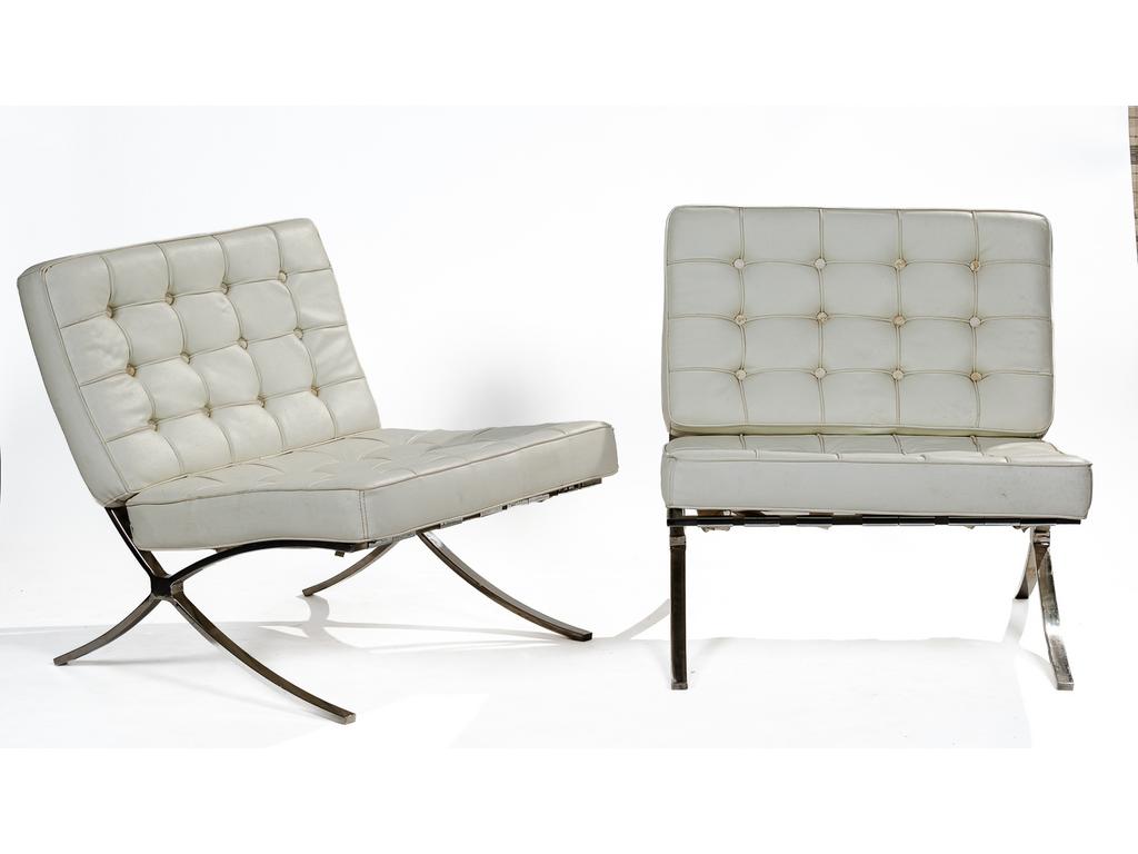 (Dans le goût de) MIES VAN DER ROHE : Paire de chauffeuses en skaï capitonné blanc, reposant sur une structure en X chromée. Dim assise : 60 x 78 cm. Hauteur : 80 cm. (Etat d'usage, skaï à nettoyer).