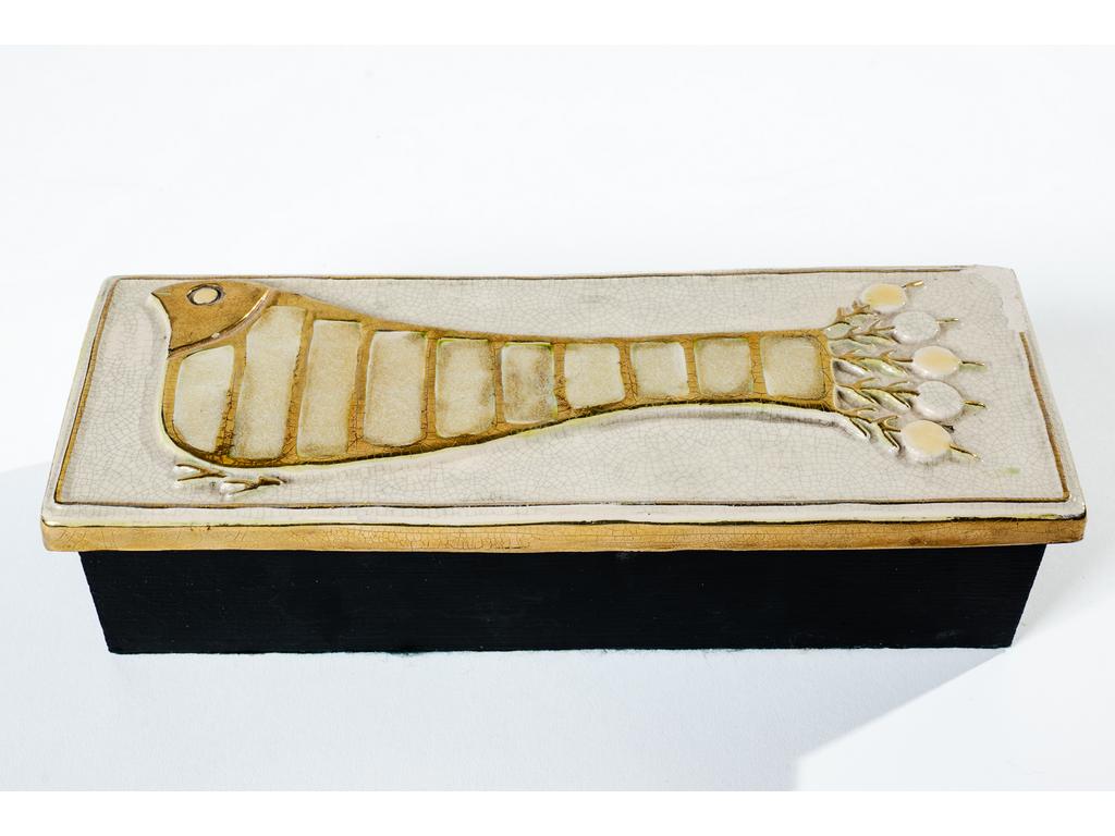 Mithé ESPELT (1923-2020) : Boîte rectangulaire en bois et feutre avec un couvercle en céramique émaillée et doré à décor d'un oiseau. (éclat à l'angle). Dim : 26 x 10 cm. Hauteur : 6.5 cm.