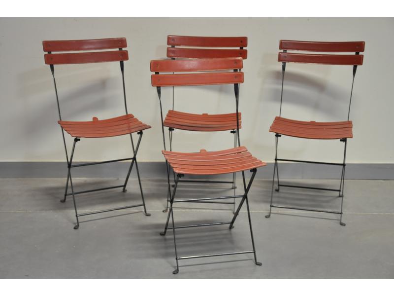 Suite de quatre chaises pliantes à lattes gainées de cuir.