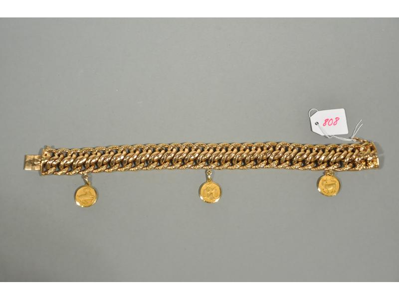 Un bracelet en or maille gourmette américaine orné de trois méda