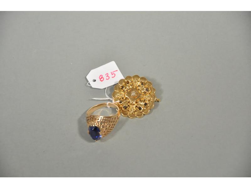 Une broche ronde en or jaune et une bague en or 14 kt ornée d'un