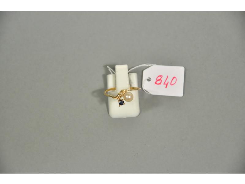 Une bague en or jaune ornée d'une perle de culture et d'un petit