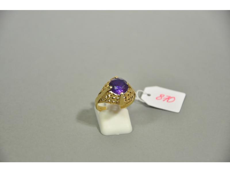 Une bague en or jaune (A.C) ornée d'une pierre violette. Tour de