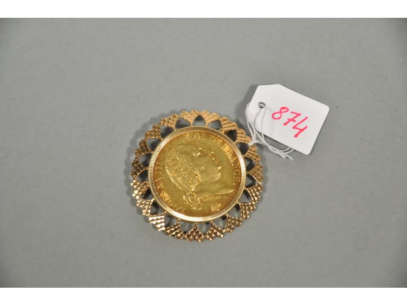 Une broche en or jaune ornée d'une pièce en or Louis XVIII de 40