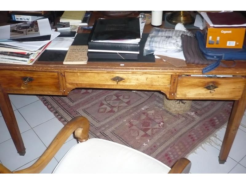 Bureau plat en bois naturel, plateau gainé de cuir, trois tiroirs en ceinture, piétement gaine. Dim. 74x149x82 cm.