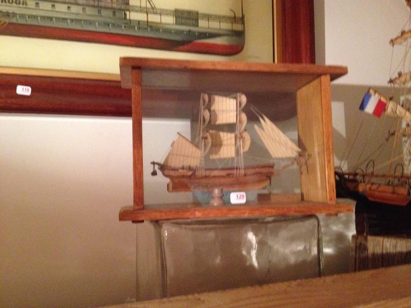Maquette de bateau en bois dans une cage en verre.