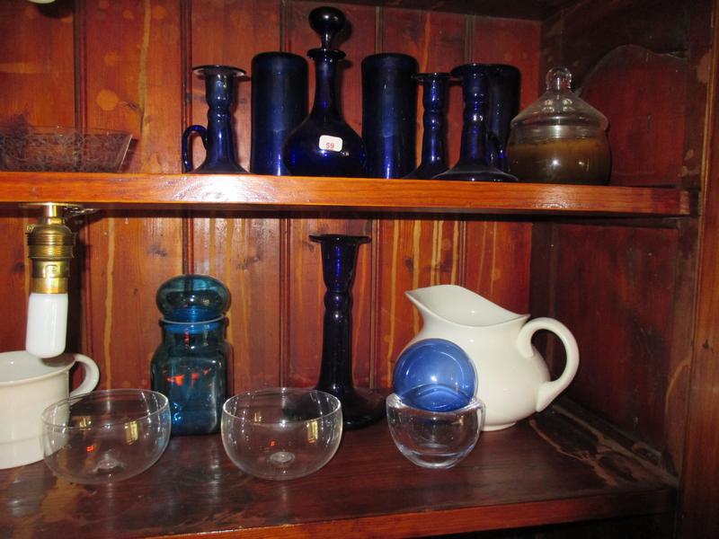 Dans le buffet: lot de verrerie bleue (bougeoirs, flacons et divers)