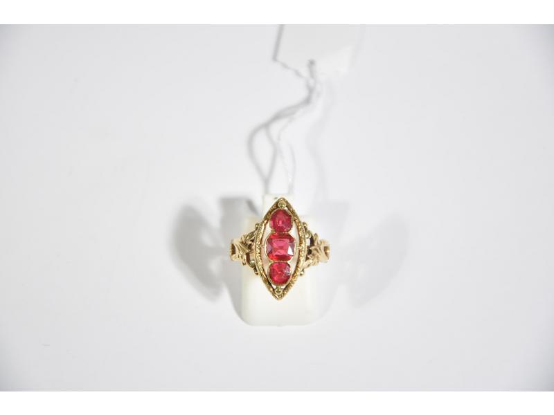 Bague marquise en or jaune ornée en serti-clos d'un doublet grenat-verre imitant le rubis encadré par deux rubis, en serti-clos.  La monture à décor de feuillage à l'épaulement.  Fin XIXe siècle.  Tour de doigt : 51.5.  Poids brut : 3g80.