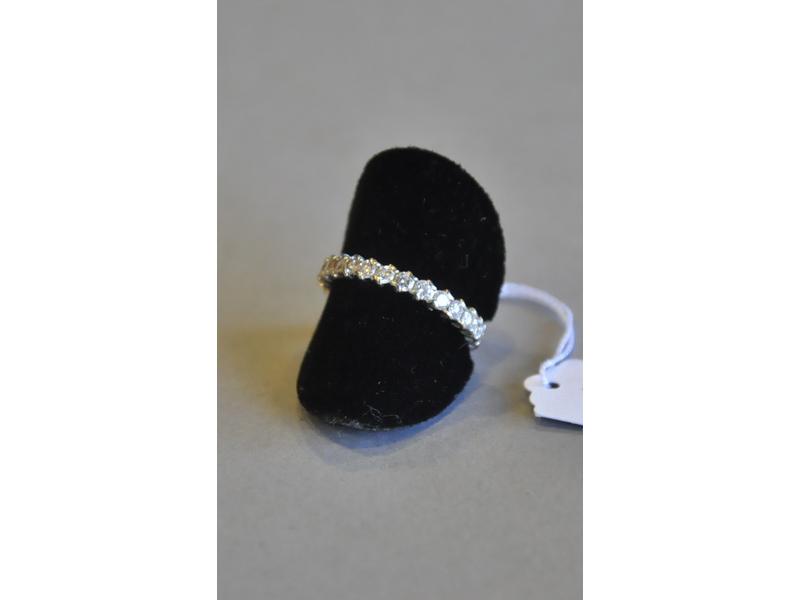 Alliance en or gris ornée en serti-griffes de vingt-quatre diamants de taille brillant totalisant 1.44 carat environ.  Tour de doigt : 55.5.  Poids brut : 2g60.  Alliance agrandie ultérieurement par élément plein non serti.