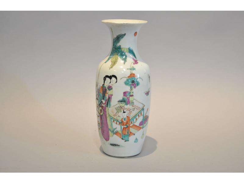 CHINE : Vase balustre en porcelaine blanche à décor peint en polychromie de deux femmes, un enfant devant une table et objets.  Au dos, des calligraphie.  Vers 1900.  Hauteur : 27.5 cm.