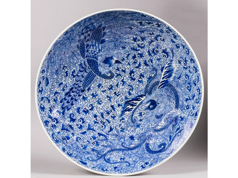 CHINE : Important plat circulaire légèrement creux en porcelaine blanc/bleu à décor en plein d'oiseaux.  Décor peint eu verso.  Epoque fin XIXe siècle.  Diamètre : 58 cm.  Bon état.