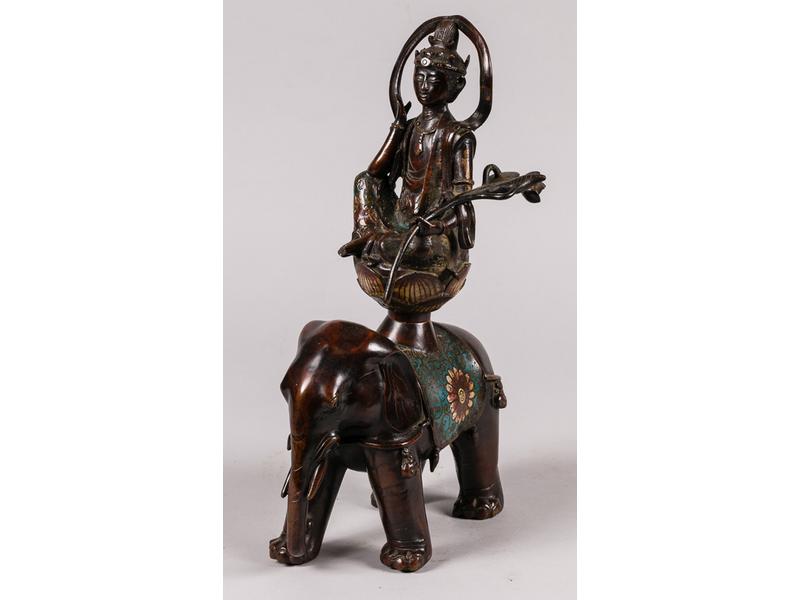 EXTREME-ORIENT : Sujet en bronze et métal patiné à décor en émaux cloisonnés représentant un Dieu assis sur une fleur de lotus porté par un éléphant.  Vers 1900.  Hauteur : 39 cm.