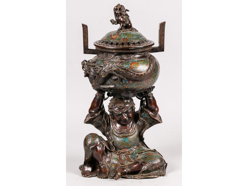EXTREME-ORIENT : Brûle-parfum en bronze et métal patiné à décor en émaux cloisonnés représentant un personnage assis tenant au-dessus de sa tête le brûle-parfum.  Vers 1900.  Hauteur : 55 cm.