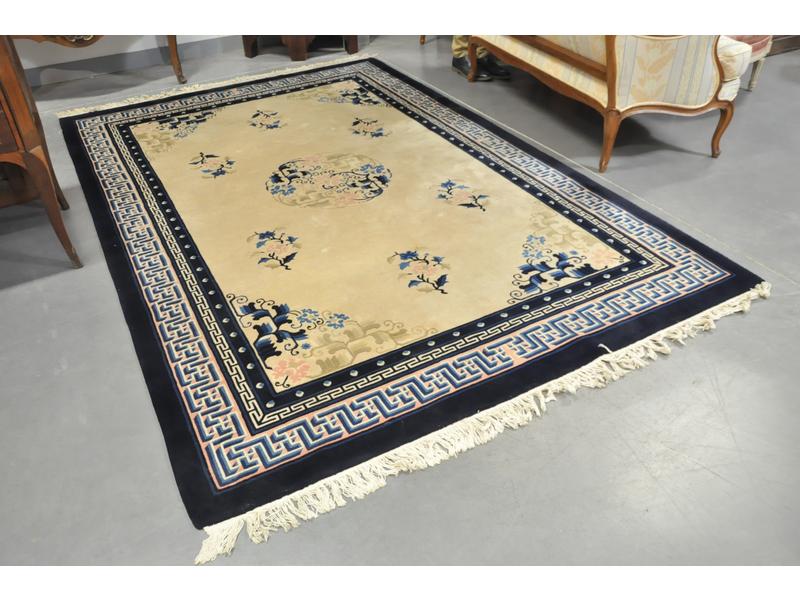 CHINE : Tapis en laine sur fond ivoire orné au centre d'un médaillon.  Les bordures à motif de grecques stylisées.  Epoque XXe siècle.  Dim.: 278x186 cm.
